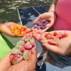 Four handfuls of Maynards Sour Patch Kids Watermelon Gummy Candy with soft, sweet, and chewy gummy pieces.