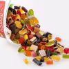 Pile of HARIBO Color Rado gummy treats pouring out of a 1kg tub, featuring a colorful mix of fruit gum, licorice, and pink raspberry-shaped candies.